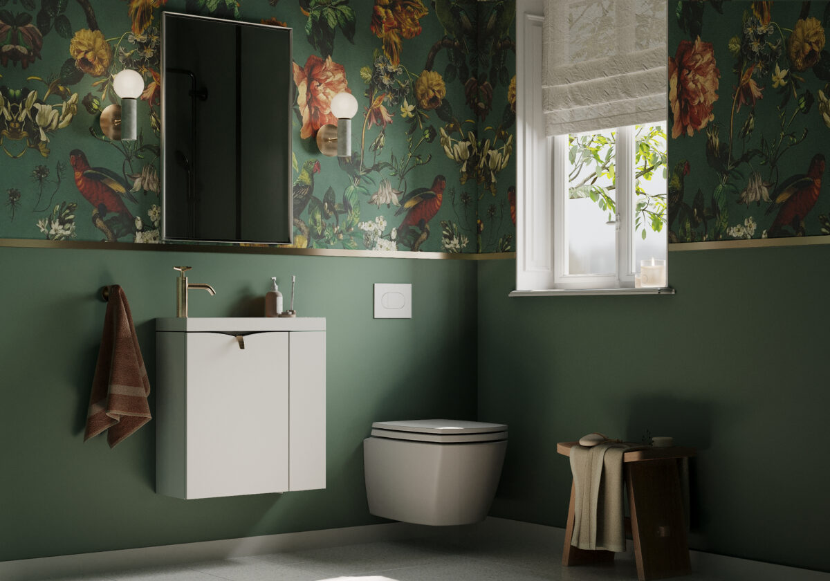 Zielona łazienka z tapetą w kolorze roślinnym z małą białą szafka łazienkową MINI z dodatkami w kolorze złotym.